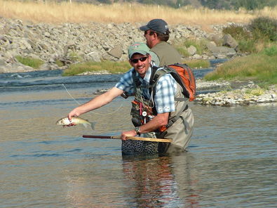 Joel-Standing-In-River-Holding-A-Fish.jpg